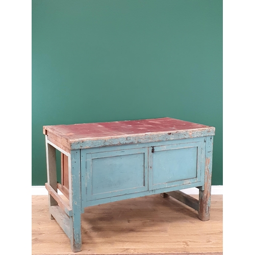 13 - A blue painted Pine Workbench with pair of panelled cupboard doors, 2ft 10