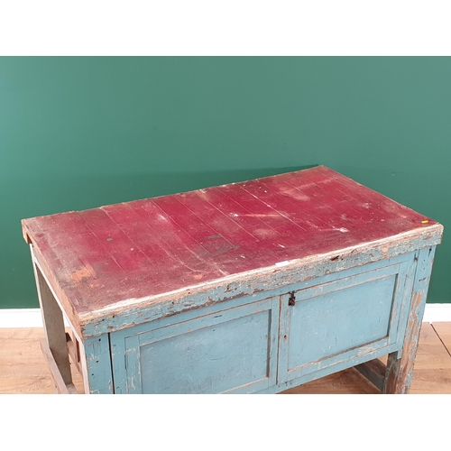 13 - A blue painted Pine Workbench with pair of panelled cupboard doors, 2ft 10