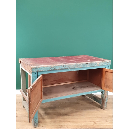 13 - A blue painted Pine Workbench with pair of panelled cupboard doors, 2ft 10