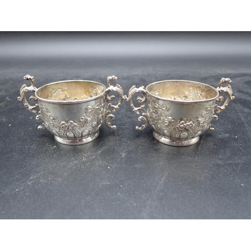 140 - A pair of Victorian silver two-handled circular Salts embossed floral swags and ribbons, London 1886