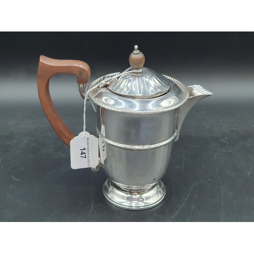 147 - A George V silver Hot Water Jug of panelled circular form with beaded rim, Birmingham 1934