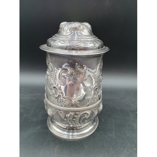 150 - A George II silver Tankard with floral embossing, rococo cartouche engraved coat of arms and motto, ... 