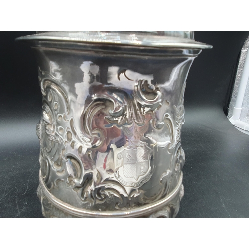 150 - A George II silver Tankard with floral embossing, rococo cartouche engraved coat of arms and motto, ... 