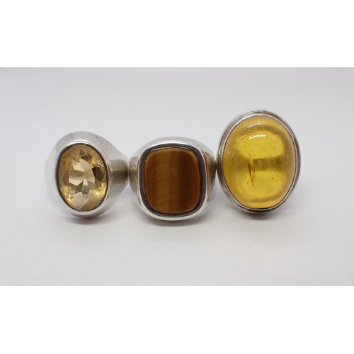 162 - Three silver Rings set tiger's eye, ambroid and yellow stone