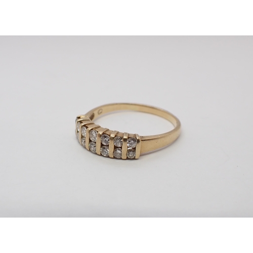 174 - A Diamond half Eternity Ring channel-set two rows of brilliant-cut stones, stamped 14K, ring size R