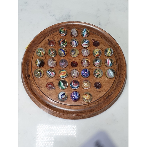 264 - A circular wooden Solitaire Board, 8 1/2in Diam. and 32 marbles