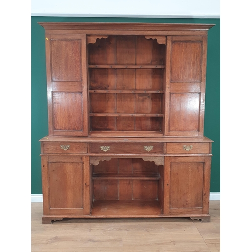 4 - An Oak Dresser and Rack, the rack with pair of cupboard doors flanking open shelves, the base fitted... 