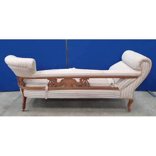 400 - An Edwardian oak framed Chaise Longue with carved decoration, striped upholstery, raised on squat ca... 