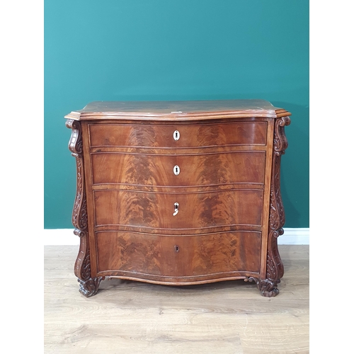 488 - A Walnut chest of four graduated drawers with canted corner applied with carved scrolled decoration