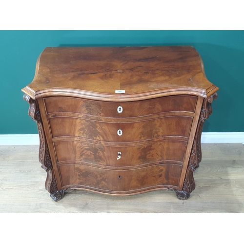 488 - A Walnut chest of four graduated drawers with canted corner applied with carved scrolled decoration