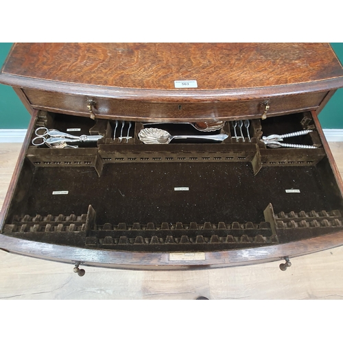 563 - An oak bow fronted Canteen Table by Mappin & Webb with four drawers part filled with plated cutlery ... 