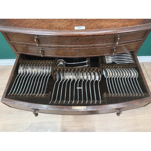 563 - An oak bow fronted Canteen Table by Mappin & Webb with four drawers part filled with plated cutlery ... 