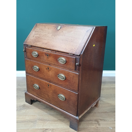 589 - A Georgian oak Bureau of small proportions fitted three graduated drawers and raised on shaped brack... 