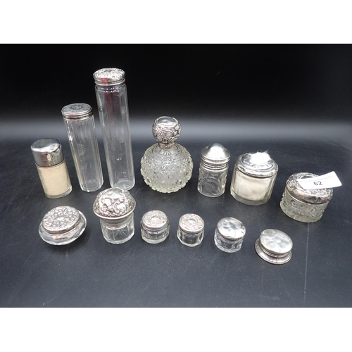 62 - Two silver lidded glass Scent Bottles and eleven various silver lidded Jars