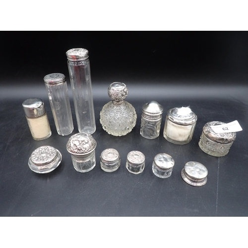 62 - Two silver lidded glass Scent Bottles and eleven various silver lidded Jars