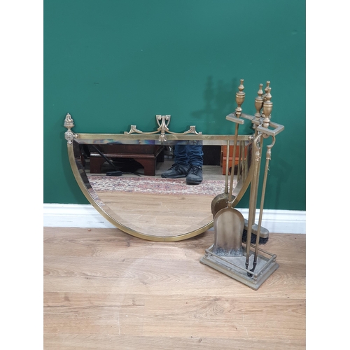 647 - An antique brass famed demi-lune Wall Mirror with torch finials 2ft 5in W x 1ft 8in H and a brass Fi... 