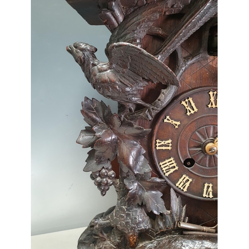 671 - A Black Forest oak Cuckoo Clock carved with fox and birds amongst vines 1ft 8in H x 1ft 4in W