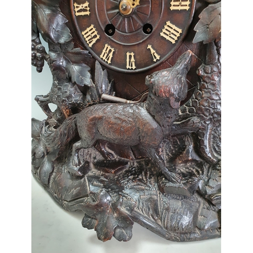 671 - A Black Forest oak Cuckoo Clock carved with fox and birds amongst vines 1ft 8in H x 1ft 4in W