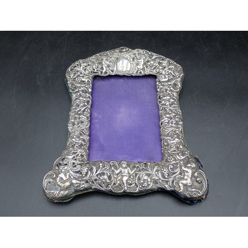 71 - A Victorian silver Photograph Frame embossed cherubs, birds and flowers, Chester 1900, a Button Hook... 