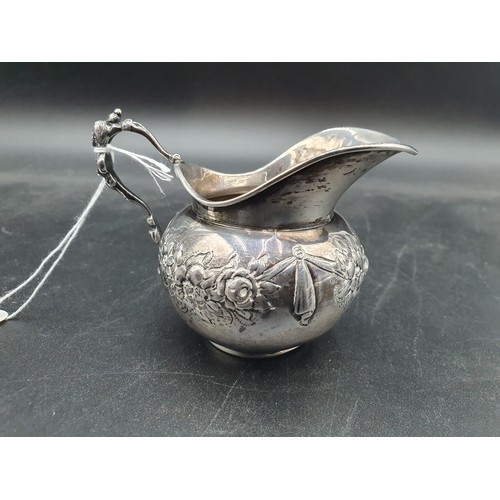 102 - An Edward VII silver Cream Jug with floral swag embossing, Import Mark Chester 1904