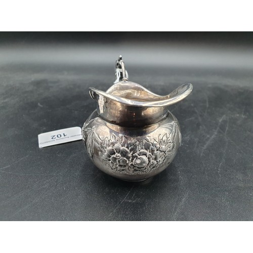 102 - An Edward VII silver Cream Jug with floral swag embossing, Import Mark Chester 1904