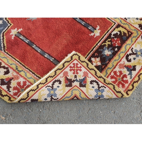 738 - A bordered Prayed Rug with stylised floral border and central red ground, 5ft 5in x 3ft 8in