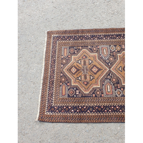 739 - A Persian Rug with multiple borders and three shaped medallions on a dark blue ground, 6ft 3in x 3ft... 