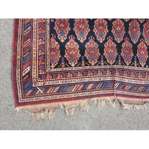 740 - A multi-bordered Persian Rug, the central ground with rows of shaped motifs on a blue ground, 7ft x ... 