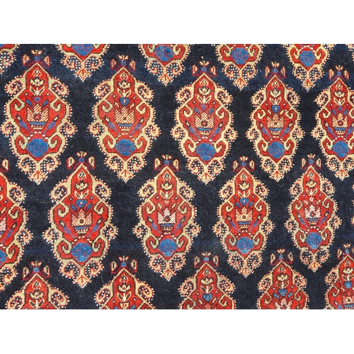 740 - A multi-bordered Persian Rug, the central ground with rows of shaped motifs on a blue ground, 7ft x ... 