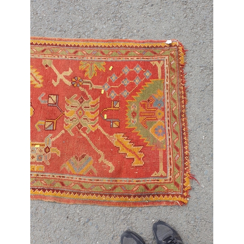 742 - A Turkish type Runner with stylised floral motifs on a red ground, worn and damaged, 11ft 8in x 3ft ... 