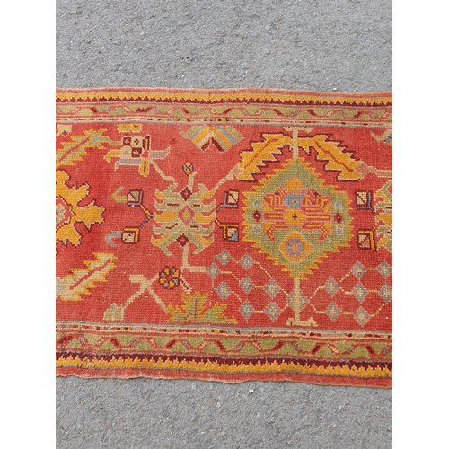 742 - A Turkish type Runner with stylised floral motifs on a red ground, worn and damaged, 11ft 8in x 3ft ... 