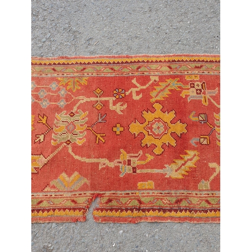 742 - A Turkish type Runner with stylised floral motifs on a red ground, worn and damaged, 11ft 8in x 3ft ... 