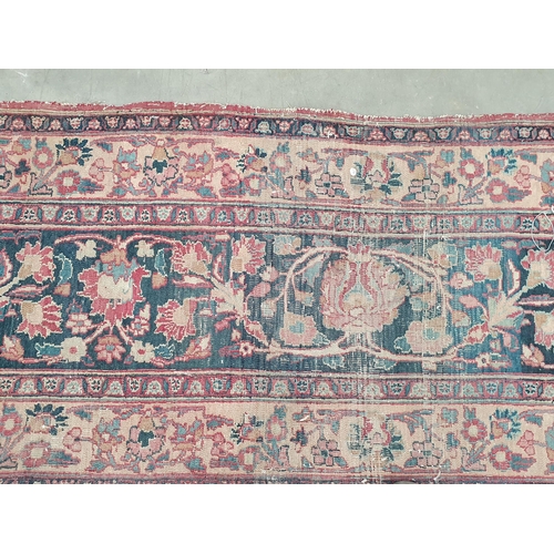 747 - A Persian Carpet of multi-bordered design, decorated scrolls and floral motifs on a blue and red gro... 