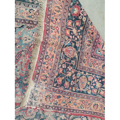 747 - A Persian Carpet of multi-bordered design, decorated scrolls and floral motifs on a blue and red gro... 