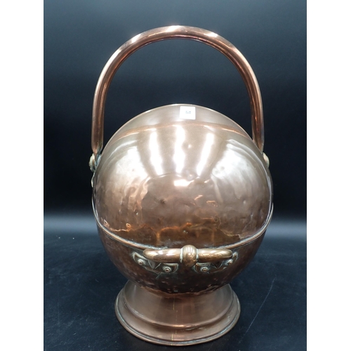 82 - An antique copper Coal Helmet with swing handle and a pair of brass tongs