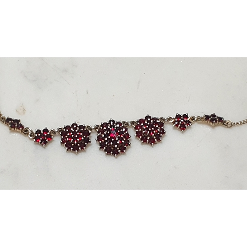 167 - A Garnet Necklace the front with graduated rosettes set round stones