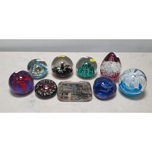 303 - Nine assorted coloured glass Paperweights, two stamped 