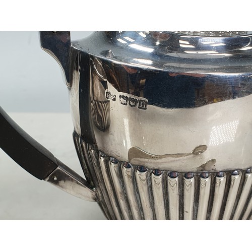 109 - An Edwardian silver three piece Tea Service of semi-lobed design and ebonised handle and finial to t... 