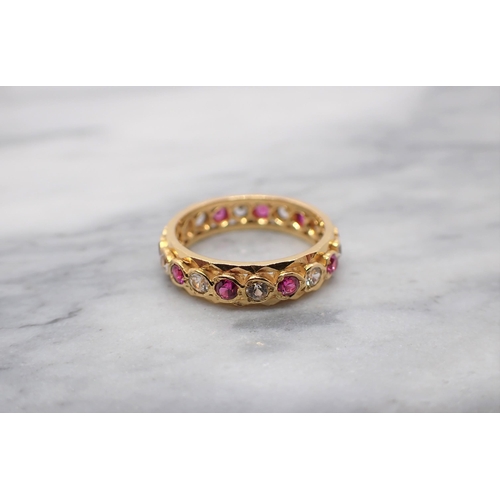 154 - An Indian Ruby and White sapphire Eternity Ring set alternating round stones, one stone deficient, u... 