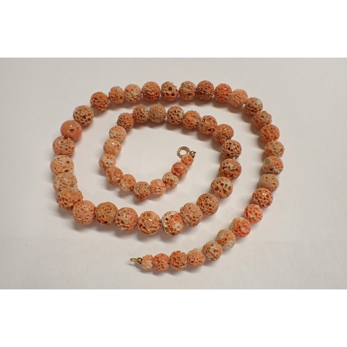 169 - A string of graduated soft Coral Beads on clasp stamped 14K, 57cms long, approx 38gms