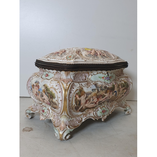 392 - A Continental porcelain Casket with hinged cover moulded chrubs and scrolls, 10in W