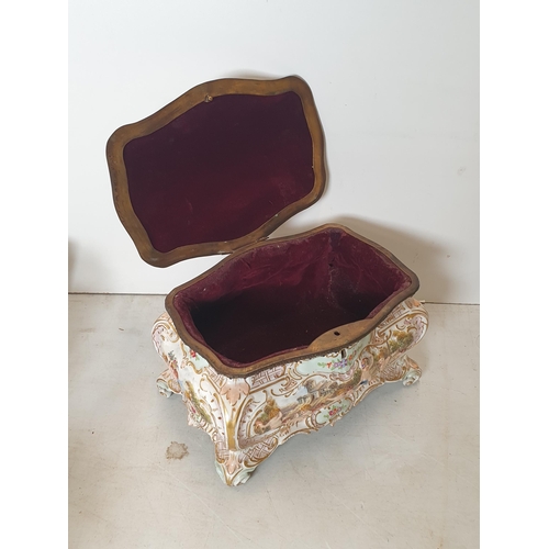 392 - A Continental porcelain Casket with hinged cover moulded chrubs and scrolls, 10in W