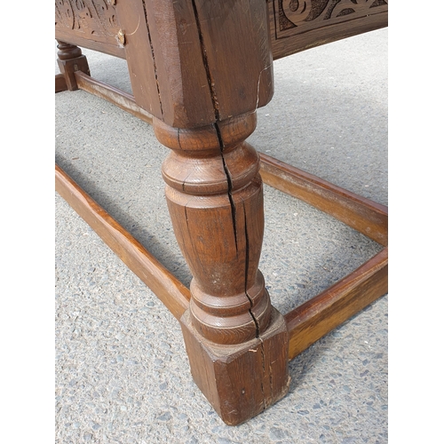 471 - A Large Oak Refectory table with carvings to the side fitted stretchers on all sides, 2ft 7