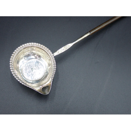 54 - A George IV Punch Ladle with coin inset silver bowl, gadroon rim and spiral whalebone handle, London... 