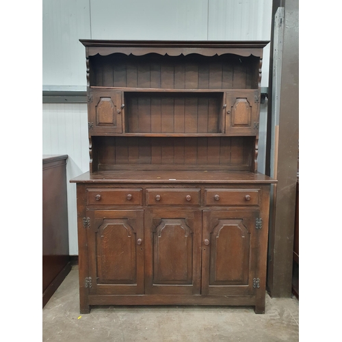 567 - A reproduction oak Dresser and Rack, the rack fitted two small cupboard doors, above three fitted dr... 