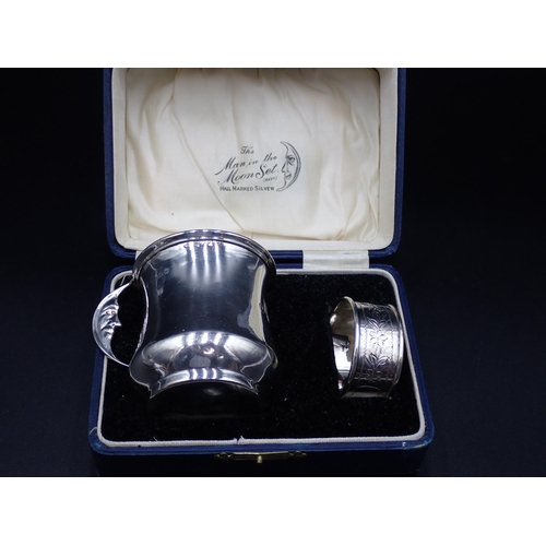 63 - A George V silver Christening Mug of waisted form with man-in-the-moon handle, Birmingham 1928, and ... 