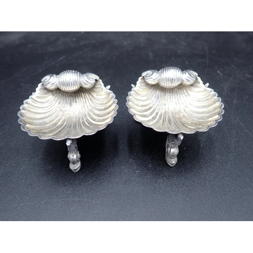 73 - A pair of Victorian silver scallop Salts on dolphin supports, London 1875