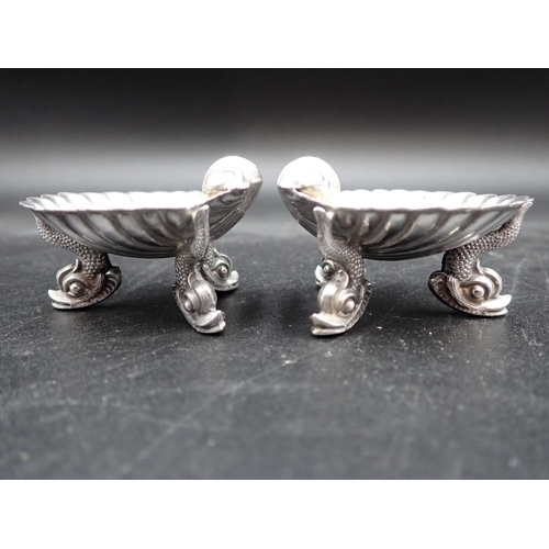 73 - A pair of Victorian silver scallop Salts on dolphin supports, London 1875