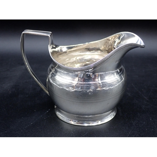 83 - A George III silver oval Milk Jug with reeded rim and engraved frieze , London 1802