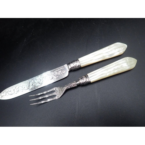 87 - A Victorian serving Knife and Fork with finely scroll engraved silver blades with Mother of Pearl ha... 